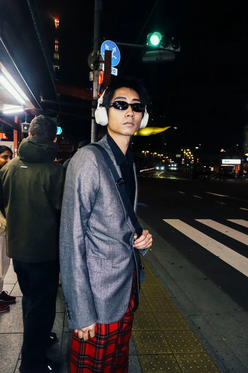 夜の街角でMilton A.N.C.を着用する人物