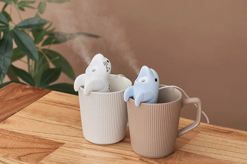 給電式ハングアニマルミストのイルカとゴマフアザラシがコップのふちに掛かりミストを噴霧する様子
