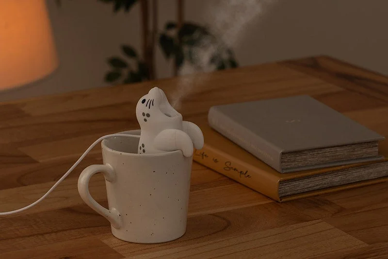 給電式ハングアニマルミストのゴマフアザラシがコップのふちに掛かりミストを噴霧する様子
