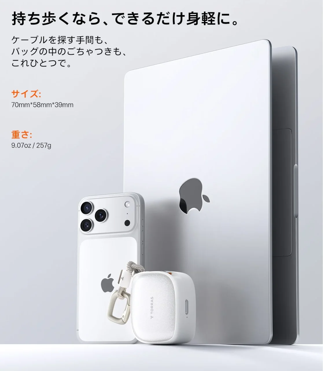 PackGo Cubeの白い本体とカラビナ。スマートフォンとタブレットの前に置かれている