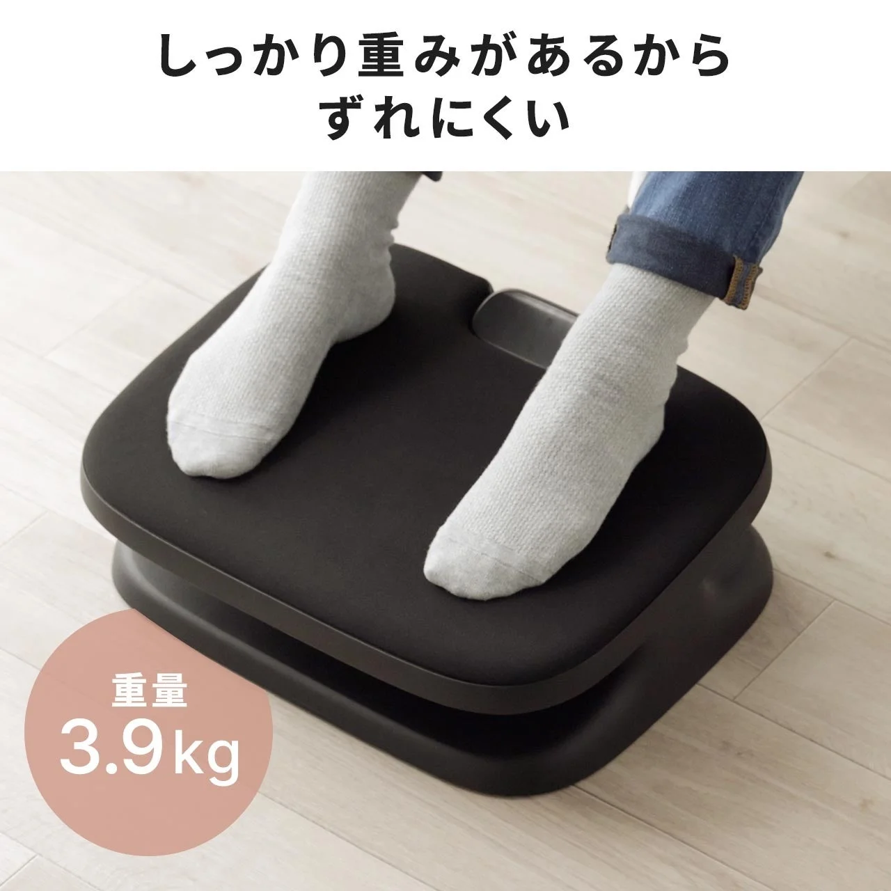 黒いフットレストに灰色の靴下を履いた両足を乗せた様子