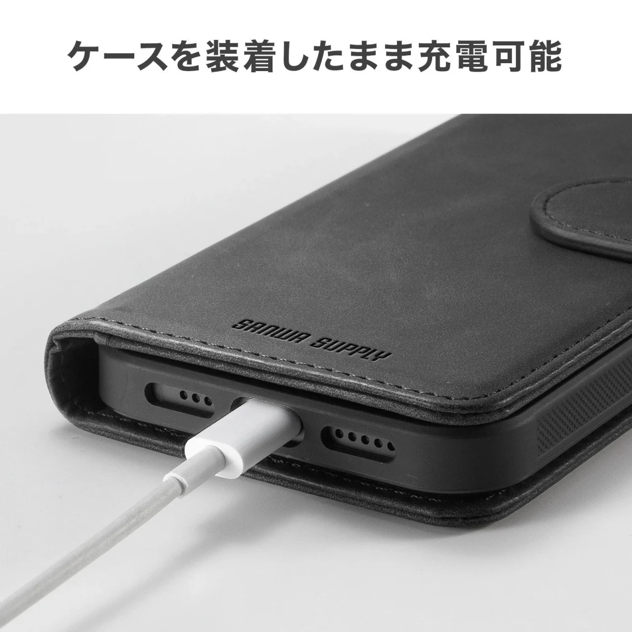 黒い手帳型ケースを装着したスマートフォンに充電ケーブルを接続した様子
