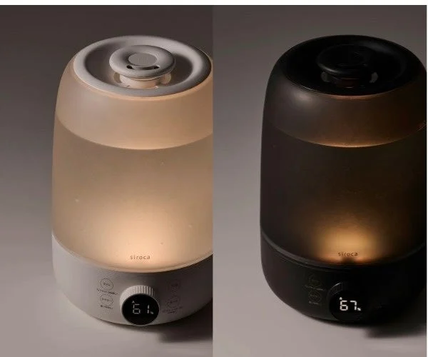 ホワイトとダークグレーの加湿器。タンク内に暖色のライトが点灯