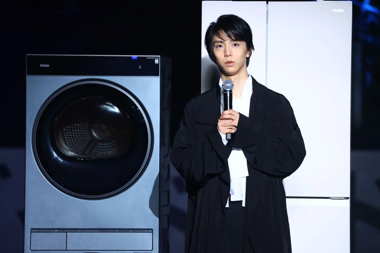 洗濯機と白い冷蔵庫の間でマイクを持つ羽生結弦さんのトークセッション