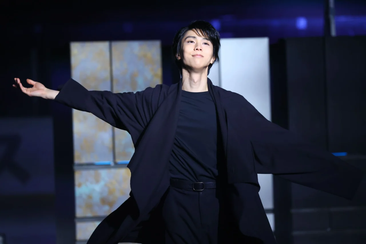 冷蔵庫を背に黒い衣装で両腕を広げる羽生結弦さん