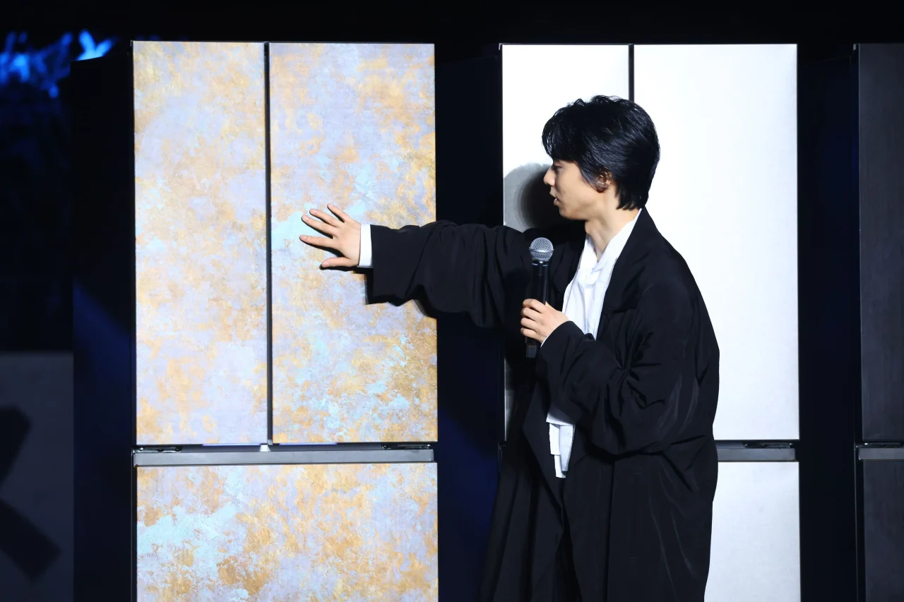金色と淡い色の模様がある冷蔵庫の扉に手を添える羽生結弦さん