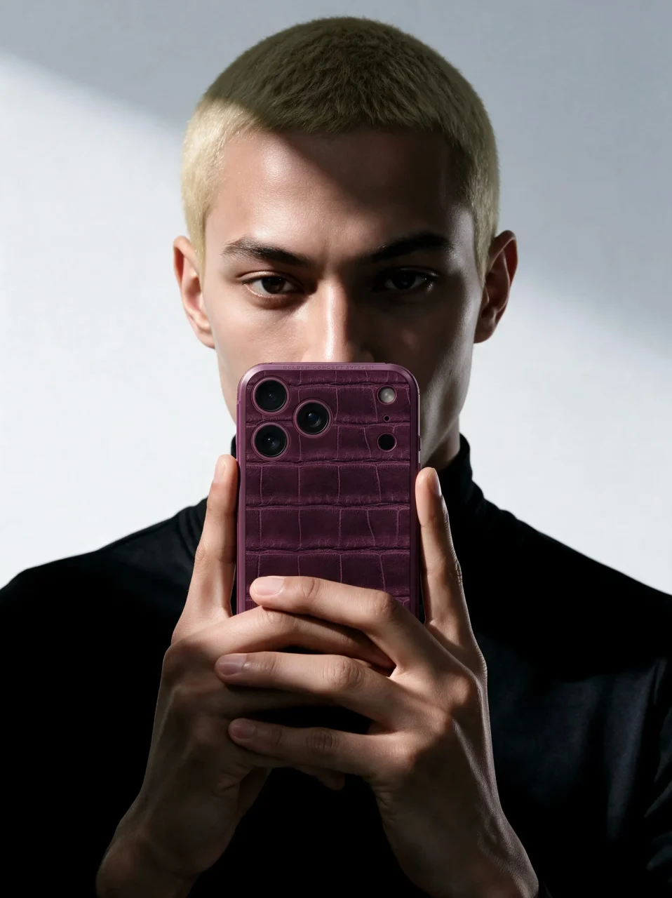 バーガンディのクロコ型押しケースのスマートフォンを構える男性