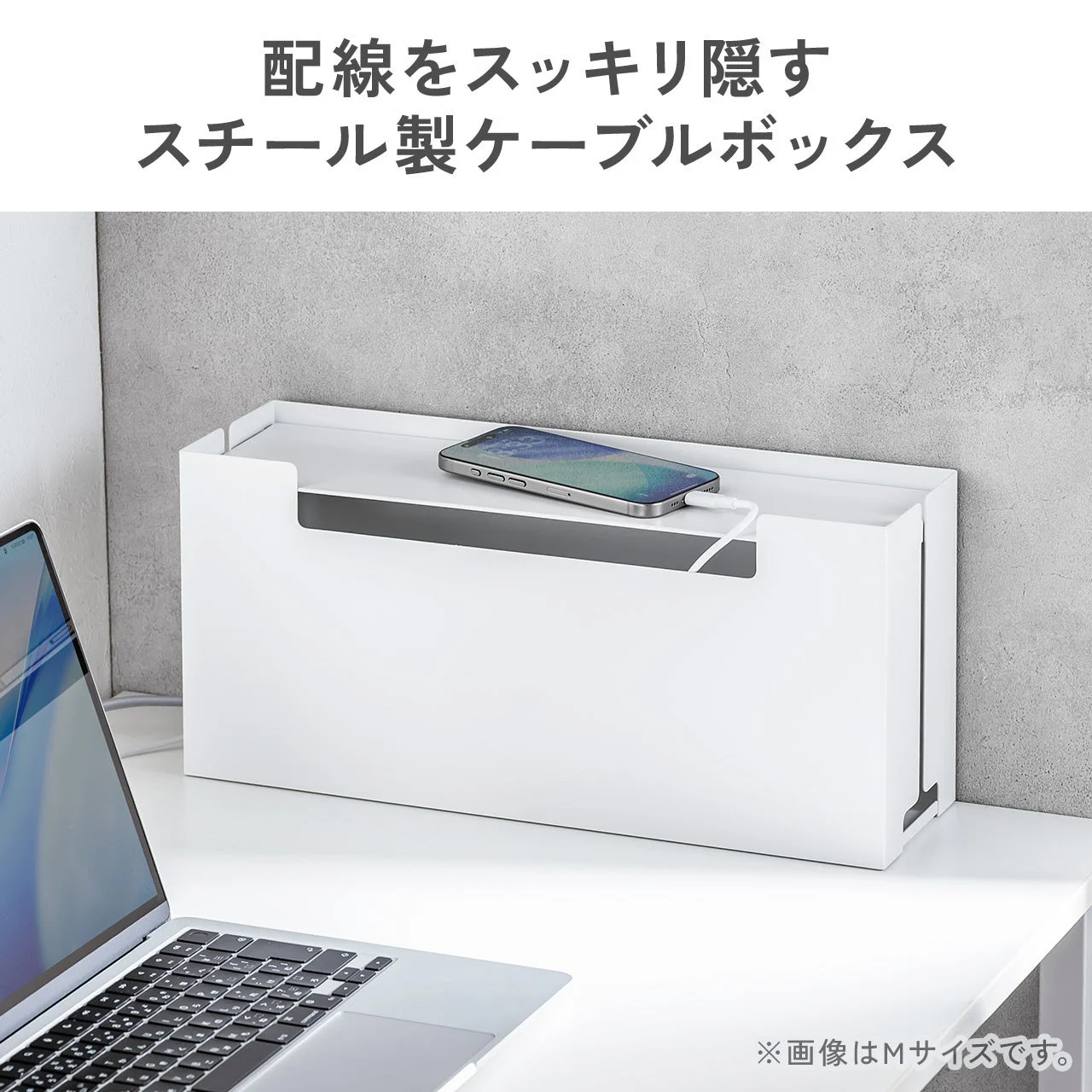 ノートPCの横に置かれた白いスチール製ケーブルボックスとスマホ