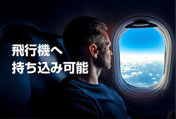 飛行機の窓から外を眺める男性と「飛行機へ持ち込み可能」の文字