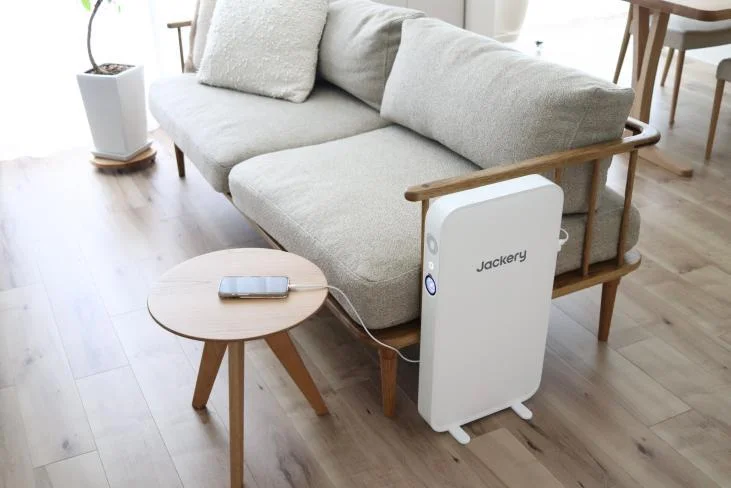 ソファ横に置かれた白い薄型のJackery ポータブル電源 SlimPower H1