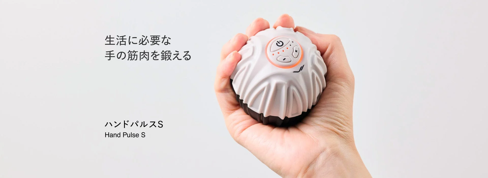手に持った白い丸型のSIXPAD Hand Pulse S。操作ボタン付き
