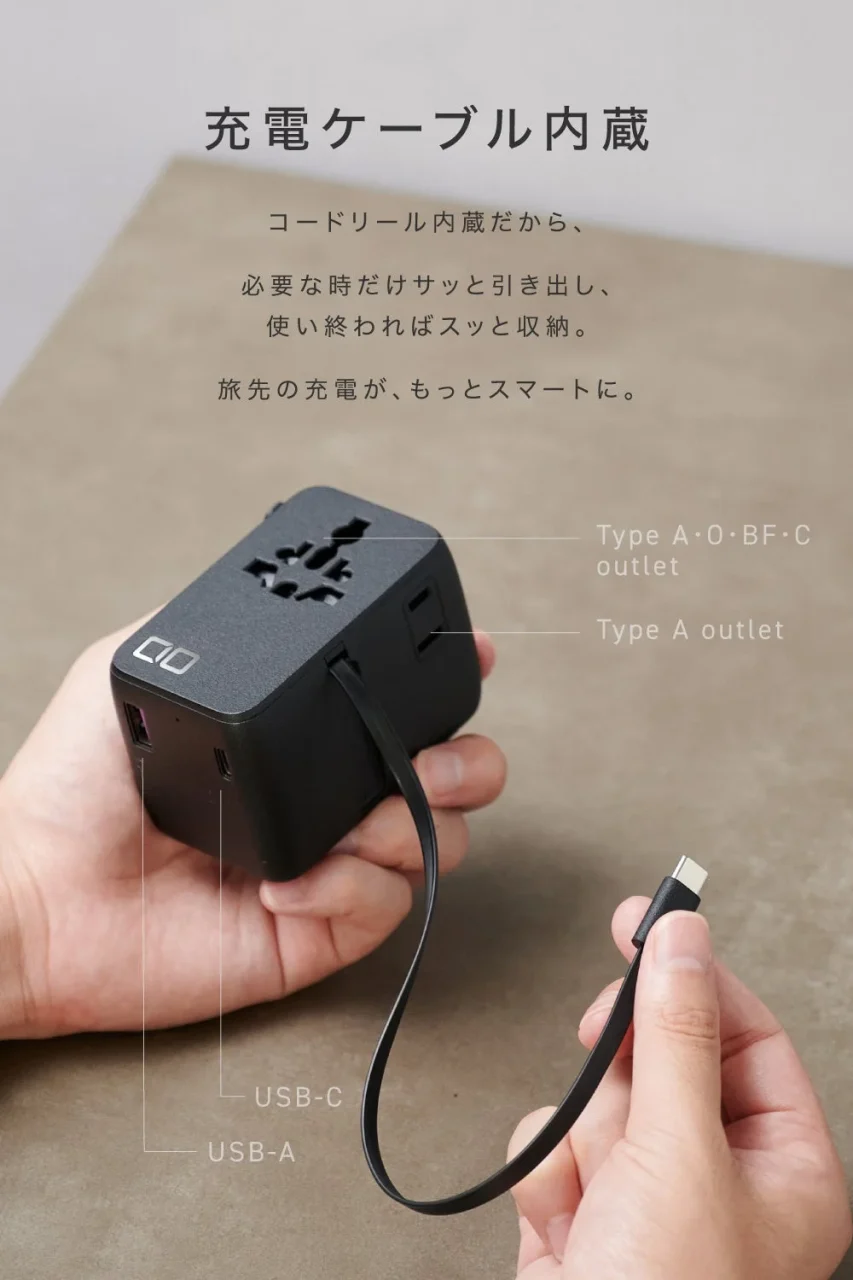 コードリール式USB-Cケーブルを引き出した黒いトラベル電源タップを持つ手