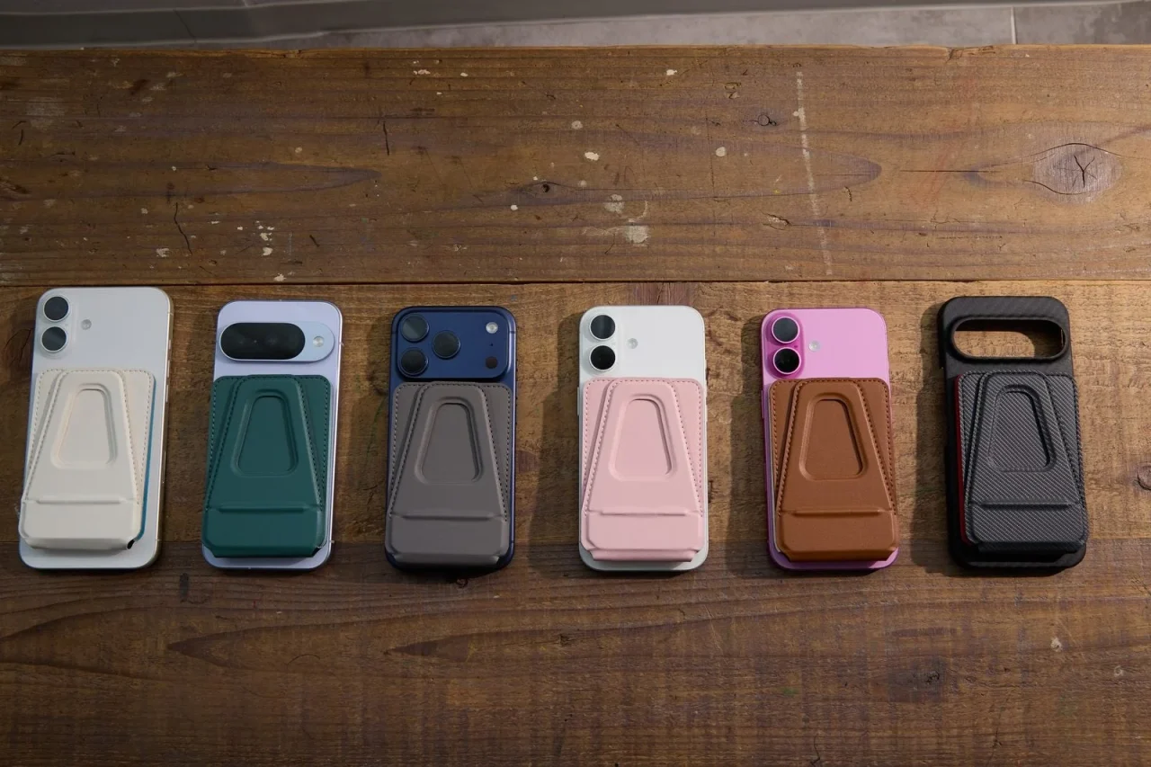 木の台に並ぶ全6色のバイカラーMAGLETTE 4-in-1を背面に装着したスマホ