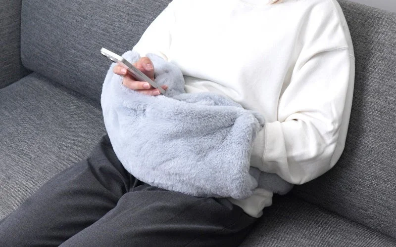 おなかぽかぽかポッケを腰に巻き、手を包んでスマホを操作する様子