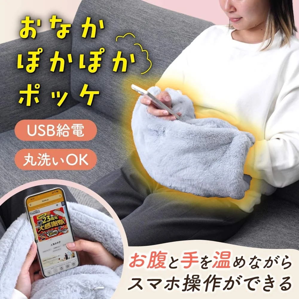 おなかぽかぽかポッケでお腹と手を温めながらスマホを操作する様子