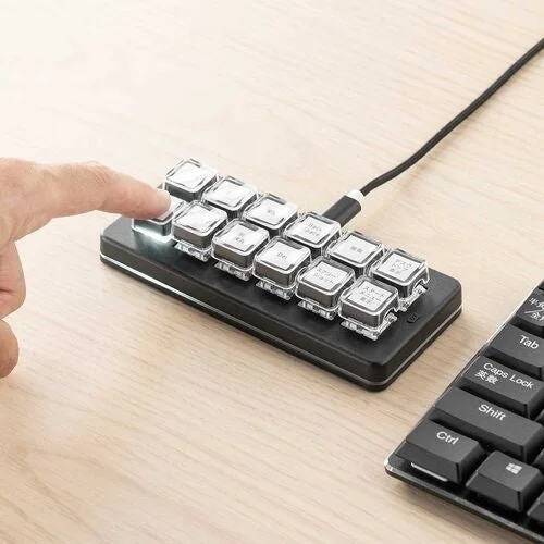 ケーブルで接続された12キーのプログラマブルキーボードを指で押す様子