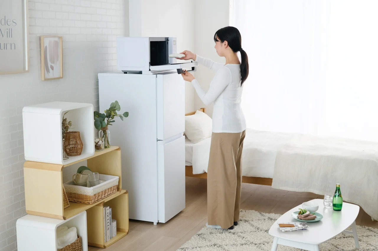 JR-SY13AR (W)の上の電子レンジを使う女性の使用イメージ