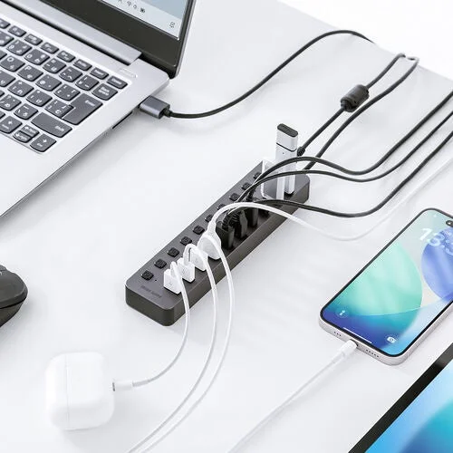 デスクに置いたコンパクトなUSBハブにスマホやイヤホンなど複数機器を接続した様子