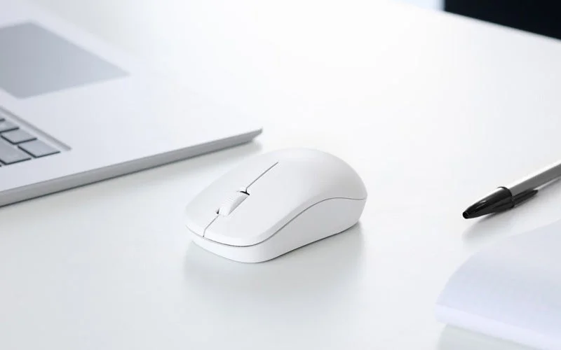 デスク上のノートパソコン横に置かれた白いBluetooth接続モデルの3ボタンマウス