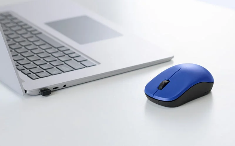 ノートPCのUSBポートにレシーバーを挿した、2.4GHz無線モデルの青いマウス