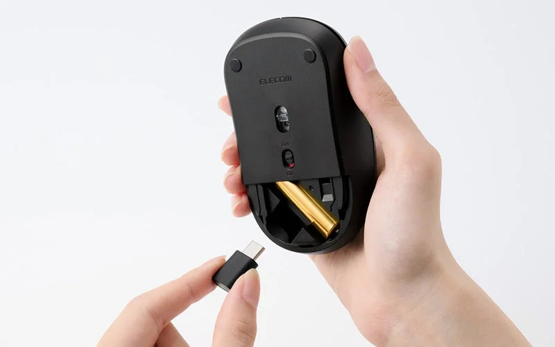 マウス裏面の電池収納部とUSB Type-Cレシーバーを持つ手