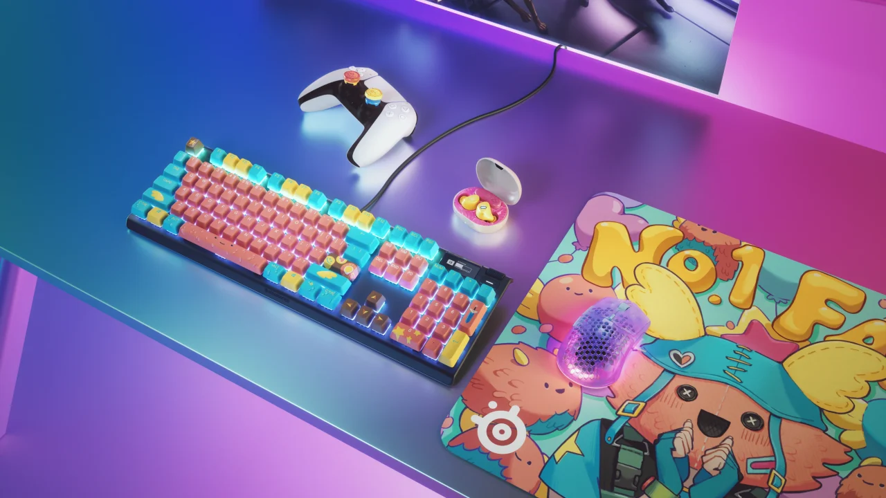 カラフルなキーボード、コントローラー、イヤホン、マウス、マウスパッドを並べたデスク