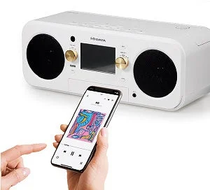 白い本体のCDレコプレーヤーとスマホの音楽再生画面を持つ手
