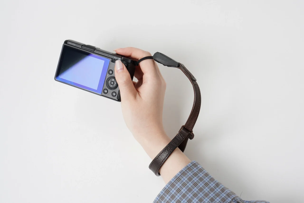 スプートニク3のストラップを手首に通しカメラを持つ手