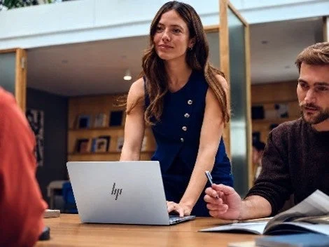 オフィスでHPロゴ付きノートPCを操作する女性と、資料を見る男性