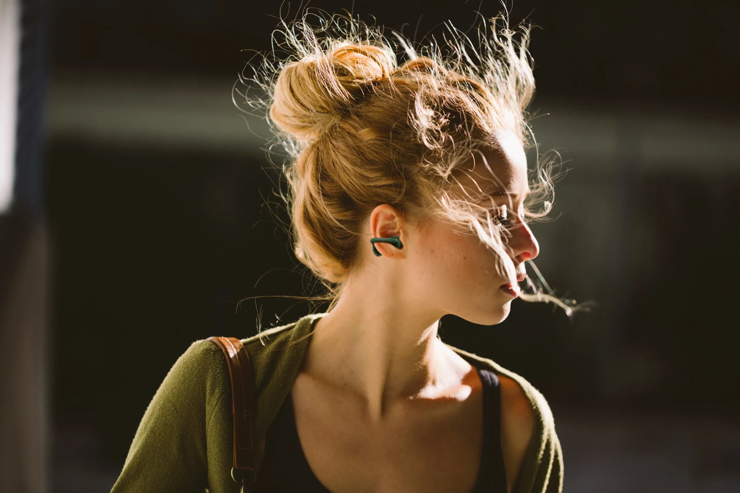 JBL Soundgear Clipsを耳に着けた、髪をまとめた女性の横顔