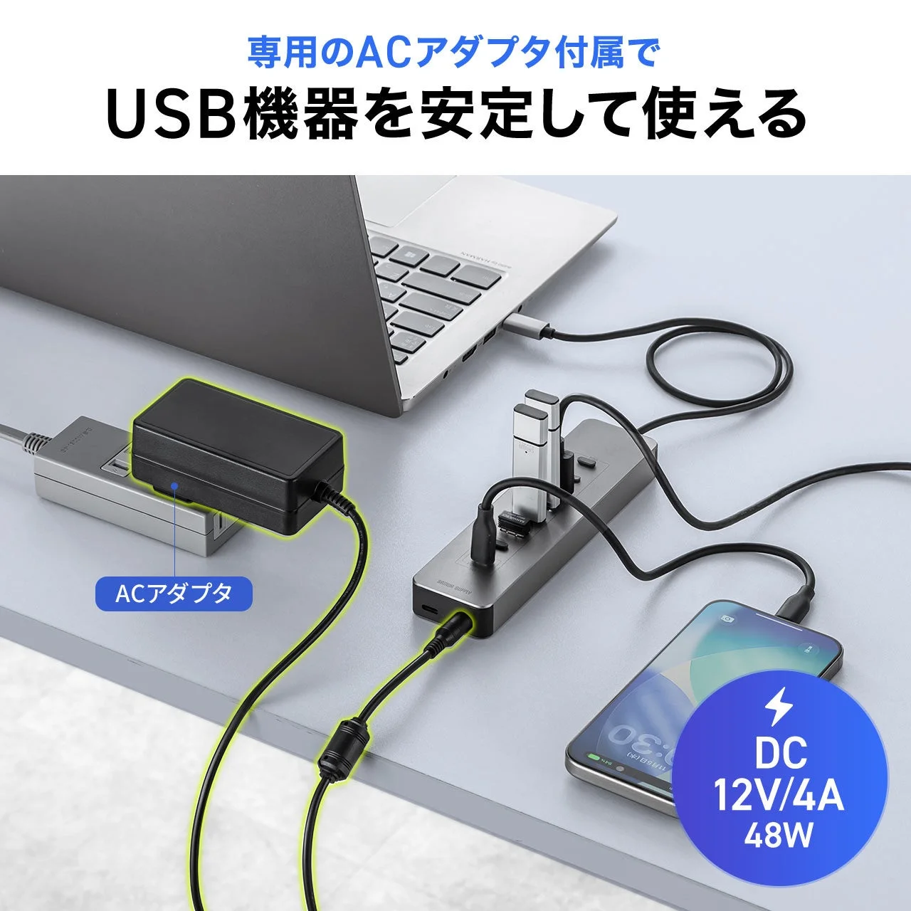 ACアダプタを接続したセルフパワーUSBハブにノートPCやスマホをつないだ様子
