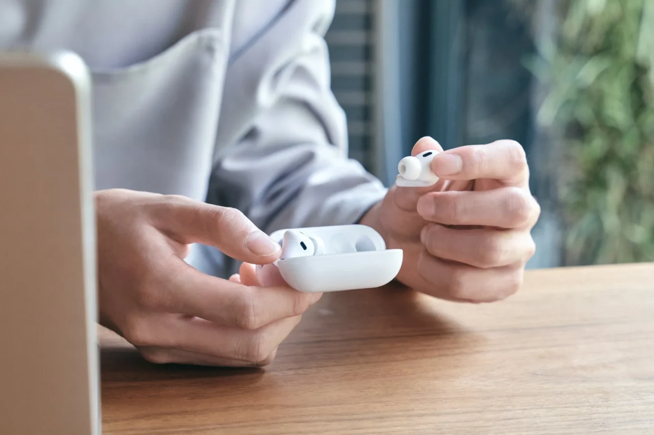 白いケースを装着したAirPodsを手に持つ様子（The Frost Air for AirPods）