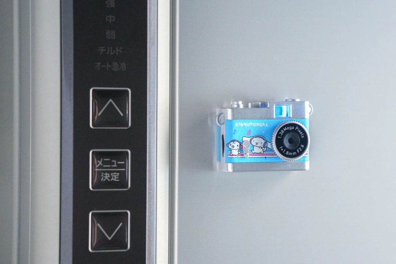 冷蔵庫の扉に磁石で固定されたシナモロールのトイカメラ