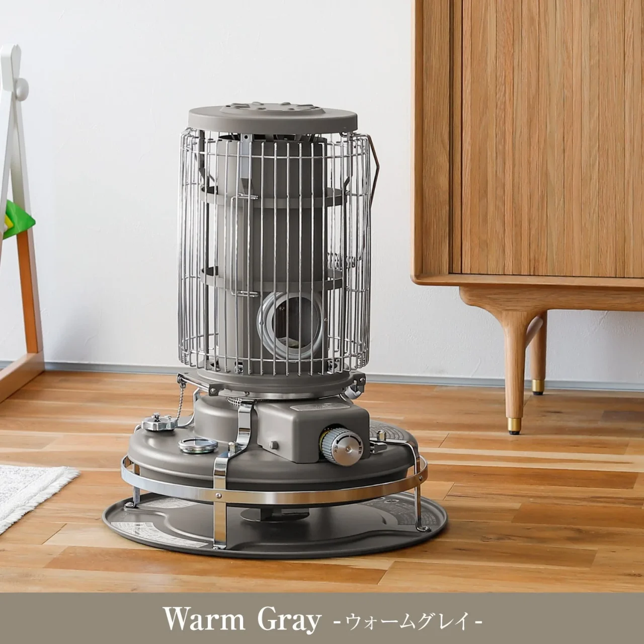 Warm Gray(ウォームグレイ）の石油ストーブを木製家具の横に置いた様子