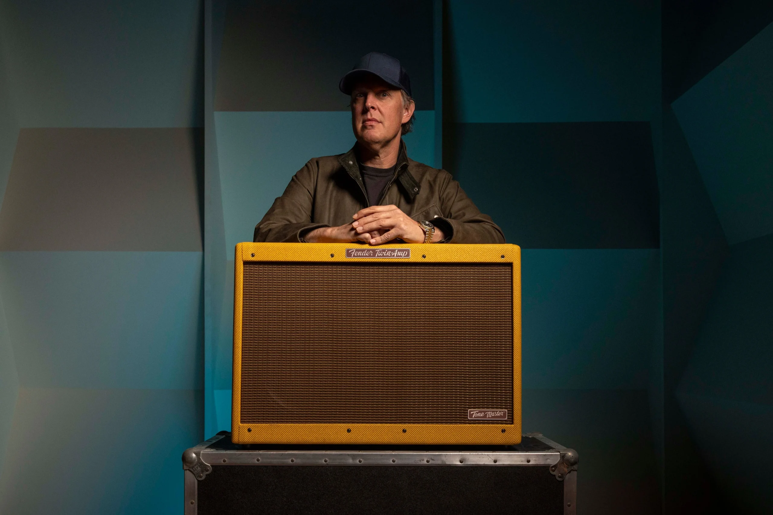 Tone Master '59 Twin JB Editionアンプの後ろで腕を組む帽子の男性