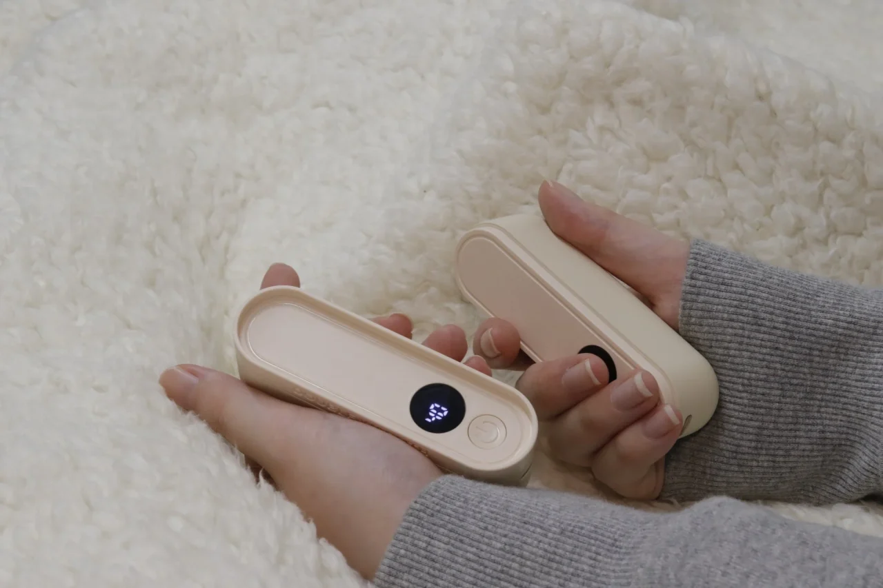 分離した2つのモバイルバッテリー機能付き電子カイロを両手に持つ様子