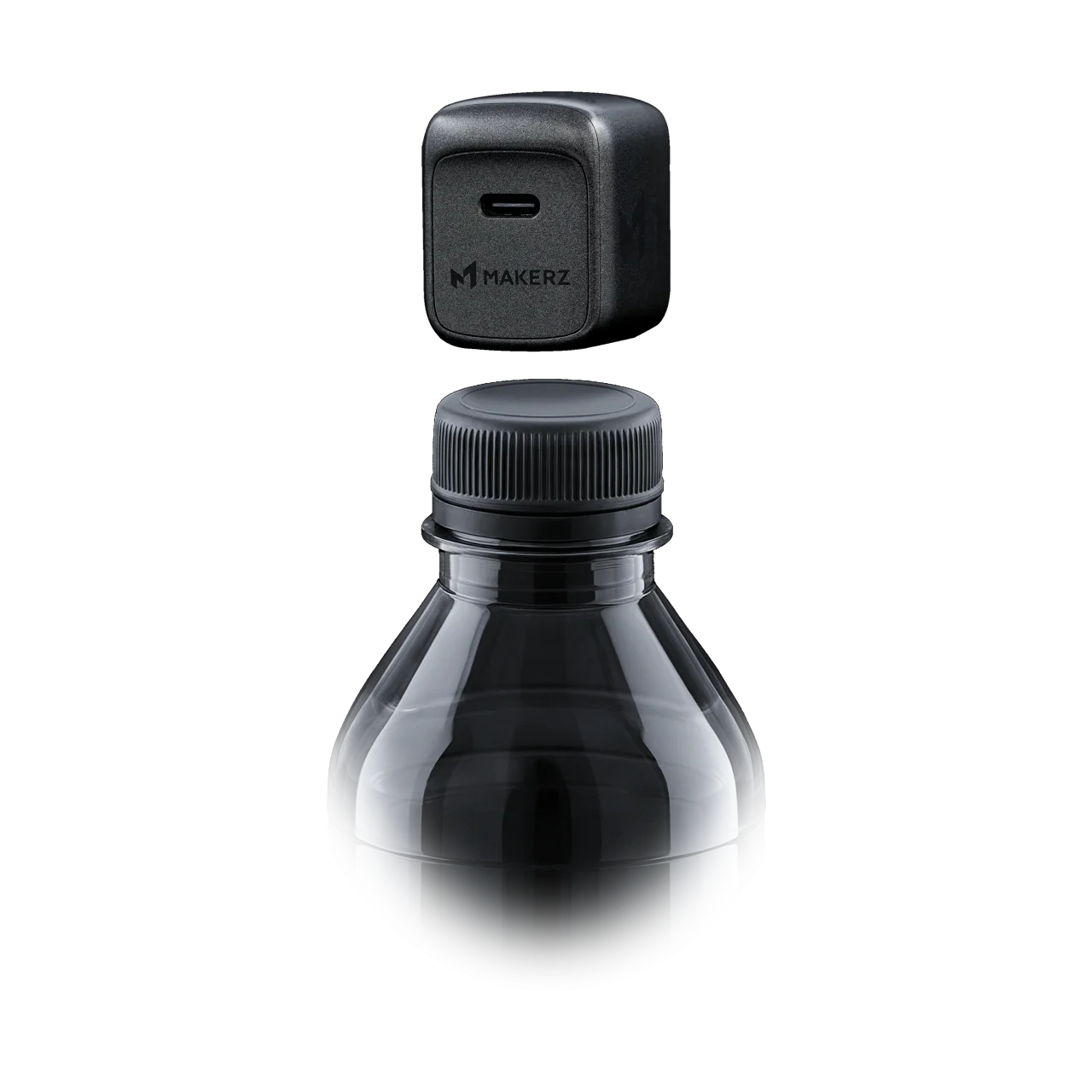 SOLIDZ Power Charger Model XS。ペットボトルキャップと並ぶ黒い超小型充電器