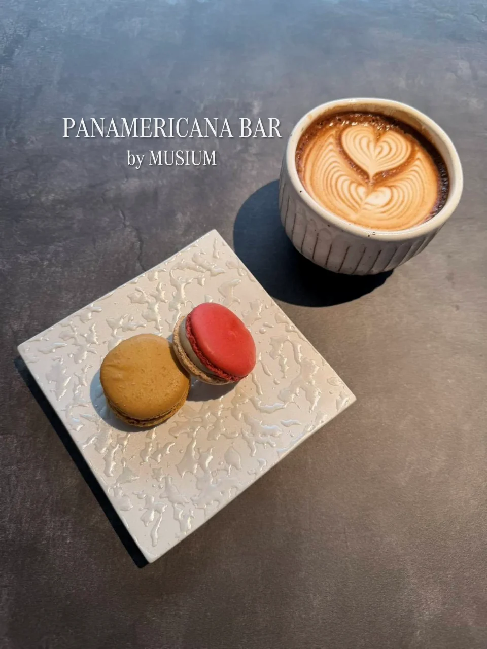 PANAMERICANA BAR by MUSIUMのラテアートのコーヒーとマカロン2個