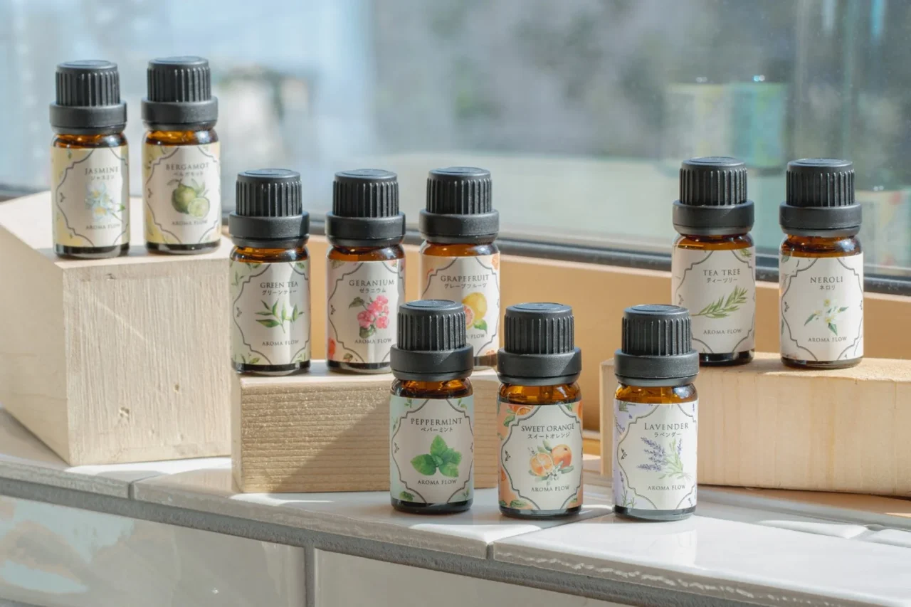 AROMA FLOWシリーズのエッセンシャルオイルの小瓶10本が木製ブロックに並ぶ