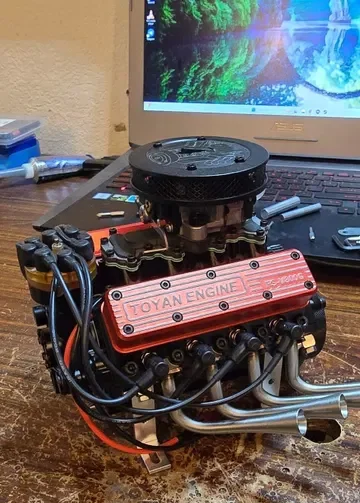 赤いTOYAN ENGINEのヘッドカバーを持つV8エンジン模型。配線と排気管が見える