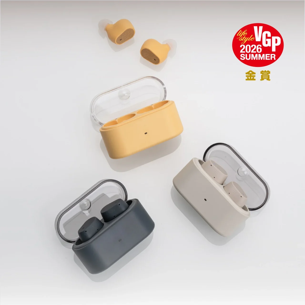 Pudding 完全ワイヤレスイヤホン。イエロー、ベージュ、ダークグレーの充電ケース