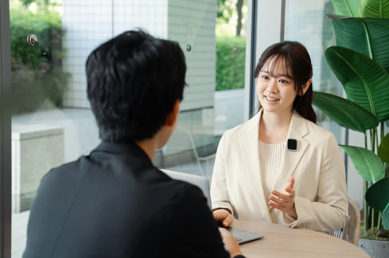 iFLYTEK AIボイスレコーダー P1の利用場面、胸元に小型機器の女性