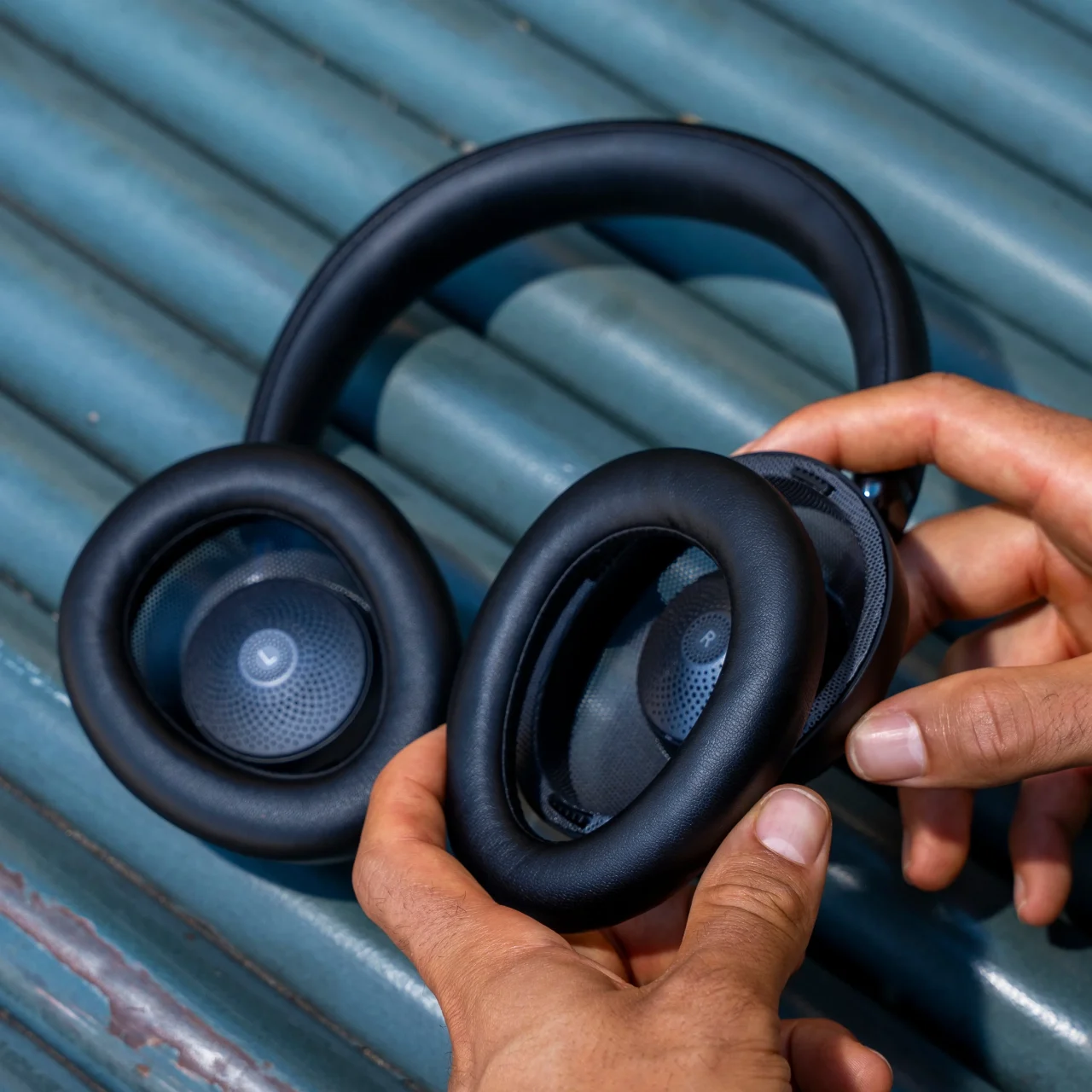 JBuds Open Wireless のイヤークッションを手で外す黒いヘッドホン