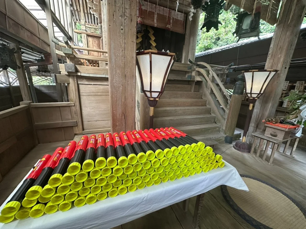神社の社殿で白布の台に並べられた火災除け御祈祷モデルの消火器具