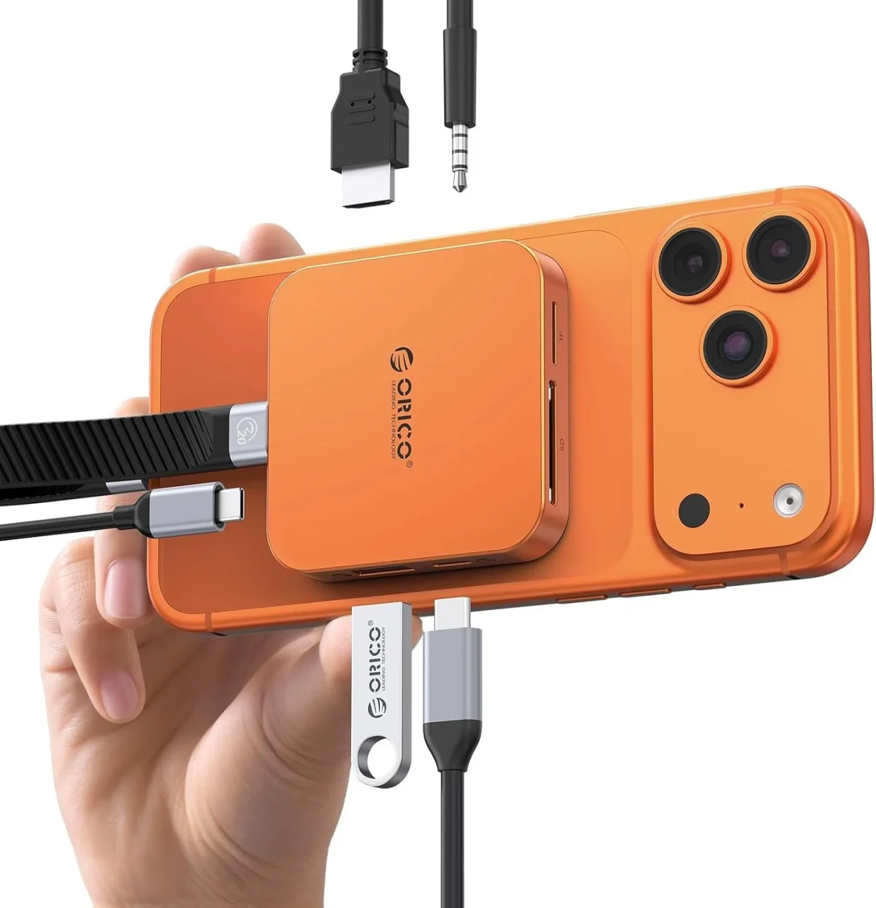 オレンジのスマホ背面に付けた8-in-1 M.2 ドッキングステーションと各種ケーブル