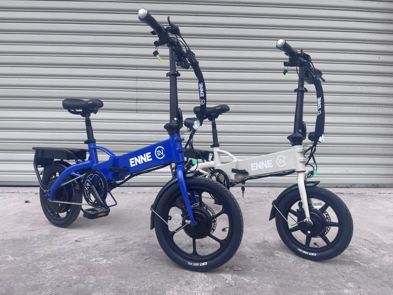 シャッター前に並ぶ青と白のENNE ZERO折りたたみ電動自転車