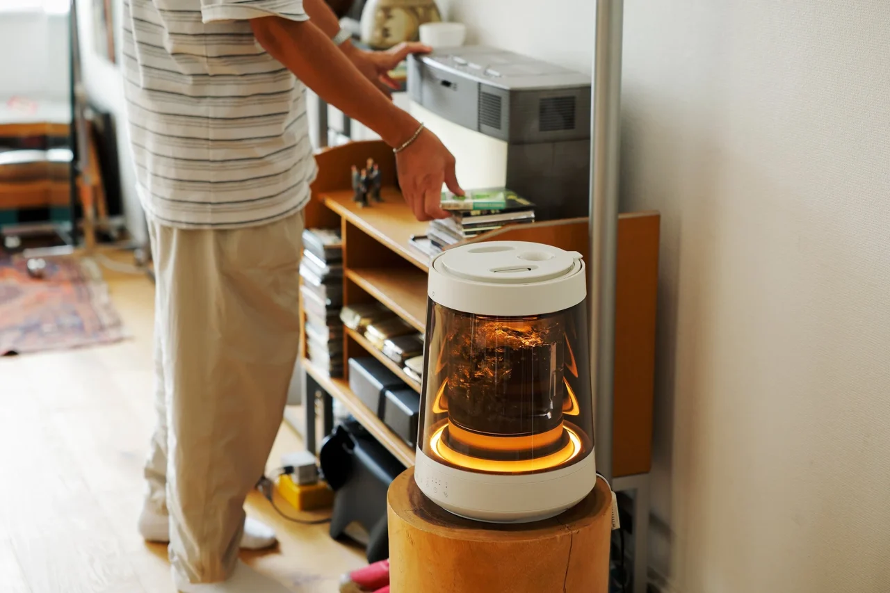 室内の台に置かれ、オレンジ色に光るガラスポットのスチーム加湿器