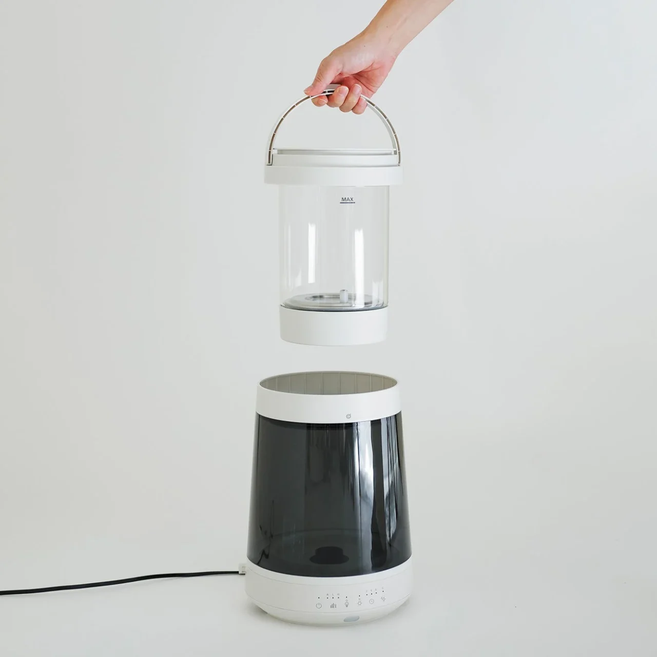 取り外したガラスポットを手で持ち上げた加湿器