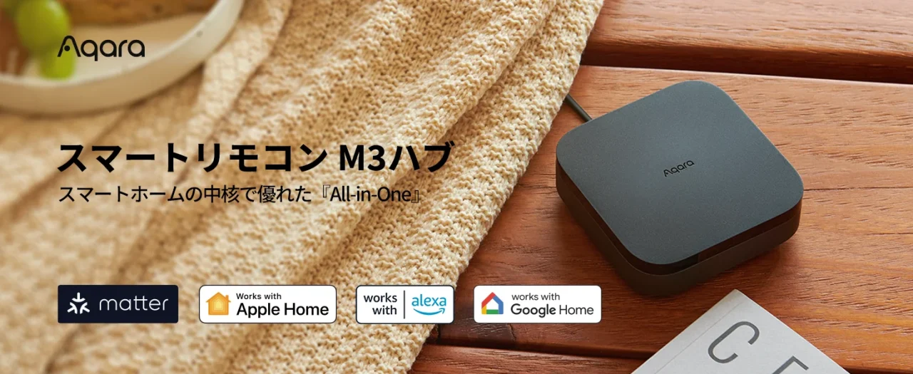 木の机に置かれた黒いAqara スマートリモコンM3ハブと対応規格ロゴ