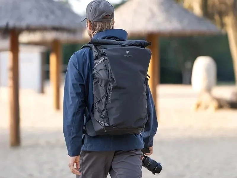 OnePro Ultralight Backpack 40Lを背負い、カメラを手に歩く人物の後ろ姿